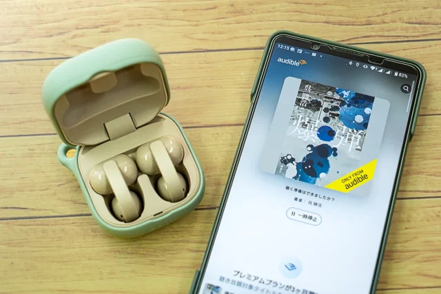 Audibleアプリを表示したスマートフォンとLinkBuds Clipの使用イメージ