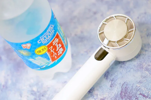 冷たい飲み物とハンディファンで夏の暑さ対策をするイメージ